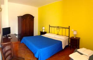 サン・ヴィート・ロ・カーポにあるLa Terrazza Di San Vitoの黄色の壁のベッドルーム1室