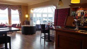 a bar with chairs and tables in a room at Porth Avallen Hotel in St Austell