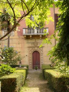 a building with a red door and a balcony at Oddi21 B&B in Albenga