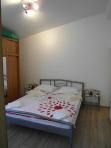 - une chambre avec un lit orné de fleurs rouges dans l'établissement Apartment Antonio, à Šibenik