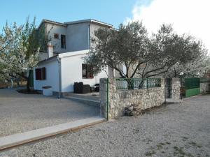a house with a stone fence in front of it at Apartment Antonio in Šibenik