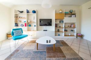 een woonkamer met een witte tafel en een blauwe stoel bij Ocean Apartment in Saint-Malo