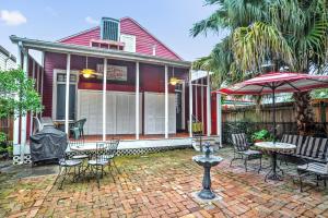 a house with a patio with chairs and an umbrella at The Burgundy Bed and Breakfast in New Orleans