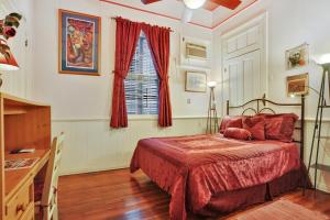 a bedroom with a red bed and a window at The Burgundy Bed and Breakfast in New Orleans