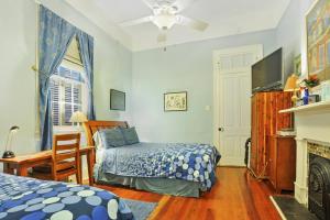 1 dormitorio con cama, TV y chimenea en The Burgundy Bed and Breakfast en Nueva Orleans