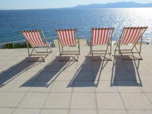 three rocking chairs sitting on a patio overlooking the ocean at Rosys Little Village in Skala