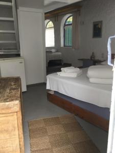 a bedroom with a bed with white sheets at Rosys Little Village in Skala