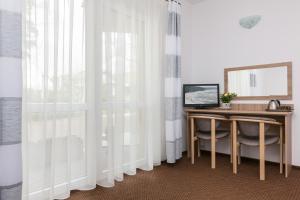 a room with a desk and a window with curtains at Dom Gościnny Oskar in Pobierowo