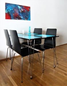 een eettafel met 4 stoelen en een schilderij bij Skorrahestar in Neskaupstaður