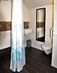a bathroom with a toilet and a shower curtain at Skorrahestar in Neskaupstaður