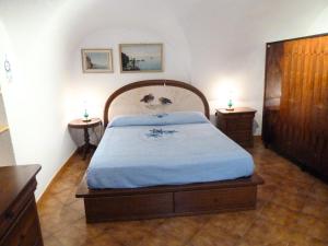 a bedroom with a large bed with two night stands at Casa Mamma Rosetta in Civezza