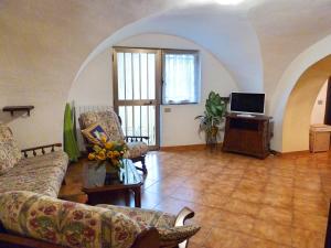 een woonkamer met een bank en een televisie bij Casa Mamma Rosetta in Civezza