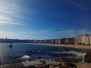 a person kite surfing in the ocean on a beach at Playa Sanxenxo in Sanxenxo