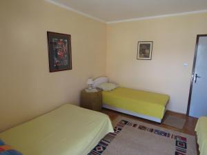 a small bedroom with two beds and a rug at Rooms Beba in Herceg-Novi