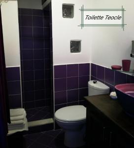 a bathroom with purple tiles and a toilet and a sink at B&B Al Comitato in Giardini Naxos