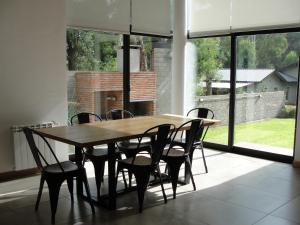 a wooden table and chairs in a room with windows at Casa Huarpes MDP en Bosque Peralta Ramos in Mar del Plata +22 photos