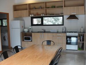 una cocina con mesa de madera y sillas. en Casa Huarpes en Mar del Plata