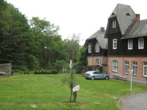 a house with a car parked in a yard at Landhaus Eickhof in Niederhaverbeck