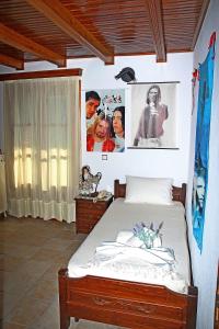 Katoikia me ta Pitharia في برينوس: غرفة نوم مع سرير وملصقات على الحائط