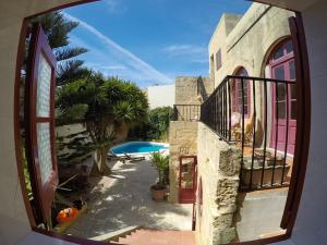 una ventana con vistas a una casa con piscina en Shanti Ghar Gozo, en San Lawrenz