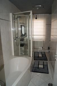 a white bathroom with a tub and a shower at Fewo-Franca in Dahn