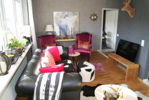 a living room with a leather couch and chairs at Fewo-Franca in Dahn