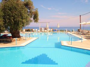 a large swimming pool with the ocean in the background at Maranton Beach Hotel in Koinyra