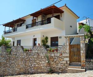 a house behind a stone wall at Pefka Apartments in Votsi