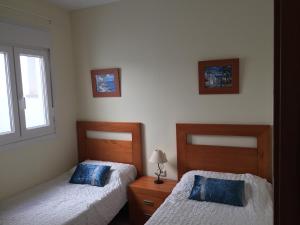 Un dormitorio con dos camas y una ventana. en Piso Oliastur, en Cotillo 16 fotos más