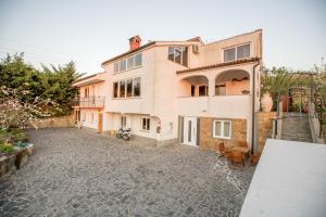 a house with a stone driveway in front of it at Apartments RM & studio Deluxe in Izola