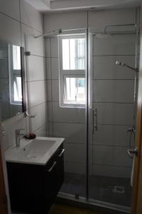 a bathroom with a sink and a glass shower at City Caribbean Hotel Boutique in Santo Domingo