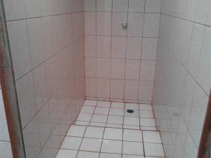 a bathroom with a pink tiled shower with a drain at Murph's Surf Shacks in Rivas