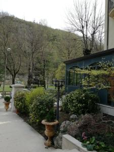 a garden in front of a building with a mountain in the background at Balneum Boutique Hotel & B&B in Bagno di Romagna