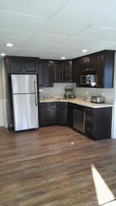 a kitchen with a refrigerator and wooden cabinets at Lily's Lodge in West Springfield