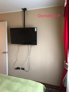 Condominio Matta Torre 1 في تيموكو: تلفزيون بشاشة مسطحة على جدار غرفة النوم
