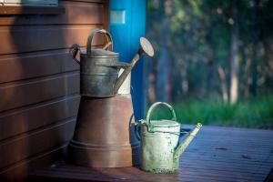 two old metal buckets sitting next to a house at Mt Cotton Retreat in Mount Cotton