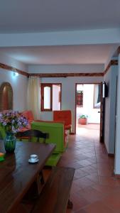 a living room with a green couch and a table at Apartahotel La Gran Familia in Villa de Leyva
