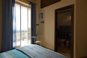 アグリジェントにあるBed and breakfast MieleZenzeroのベッドルーム1室(ベッド1台付)、バスルーム(窓付)が備わります。