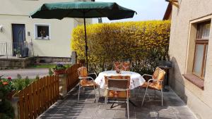 een tafel en stoelen met een parasol op een patio bij Ferienhaus Richter in Bad Schandau