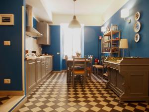 cocina con paredes azules, mesa y sillas en Le Stanze di Pietro, en Roma