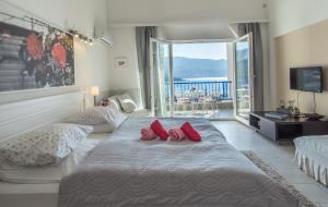 a bedroom with a large bed with red pillows and a balcony at Apartments Inspiration in Budva