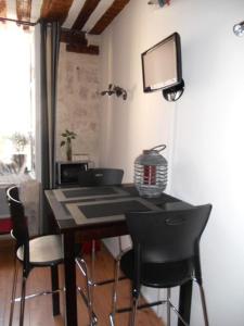 a dining room table with chairs and a television on the wall at Coeur de Provence STC in Avignon