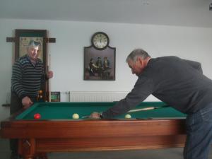 two men playing a game of snooker at Chambres d'hôtes Le Chardon Fleuri in Teuillac