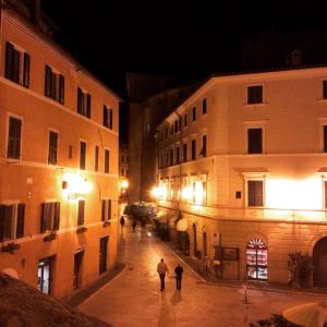 ピティリアーノにあるAppartamento Palazzo Sadunの夜の通りを歩く二人