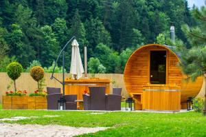 a wooden cabin with a table and chairs and an umbrella at Stara Decha in Krynica Zdrój