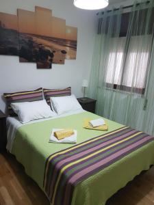 ein Schlafzimmer mit einem Bett mit zwei Handtüchern darauf in der Unterkunft Villa Oliveira Apartments in Lagos