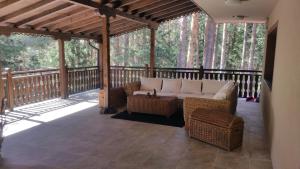 a screened porch with a couch and wicker chairs at Hunting Residence Lodge in Panichishte