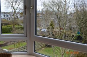 two windows in a room looking out onto a yard at Holiday Apartment Dunfermline in Dunfermline