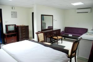 a bedroom with a bed and a couch and a mirror at Paradise Inn Hotel (Tabasum Group) in Ajman 