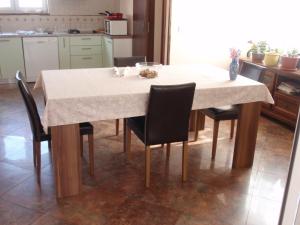 uma mesa de cozinha com cadeiras e uma toalha de mesa branca em Apartment Vera em Zadar